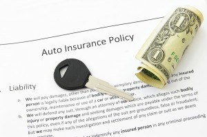 auto insurance policy and car key with money