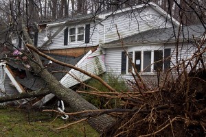 ANDOVER, NJ - OCT 30: An uprooted tree laying across the front porch of a home after Hurricane Sandy made landfall in the northeast region of the US in Andover, New Jersey on October 30, 2012.