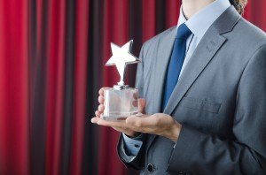 bigstock-Businessman-awarded-with-star--27415880-top-rank-trophy