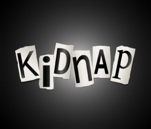 Illustration depicting cutout printed letters arranged to form the word kidnap.