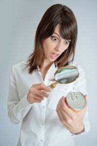 Shocked young   woman inspecting a can?s nutrition label with a