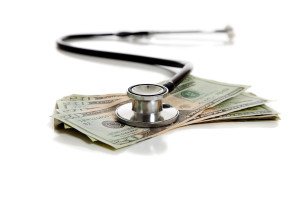 A stethoscope and American money on a white background - Healtcare cost concept